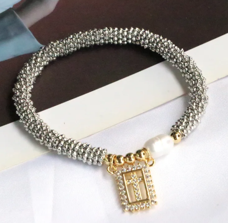 Pulsera con cruz, circonias y perla.