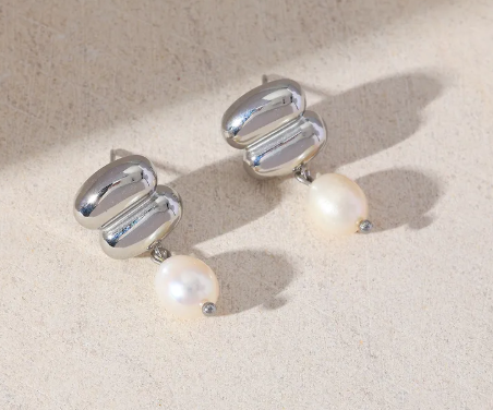 Aretes con perla colgando. Color plateado.