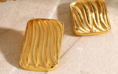 Aretes rectángulos grandes con líneas. Color dorado.