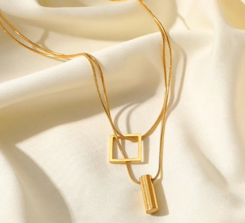 Collar doble con dije cuadrado y cilindro.