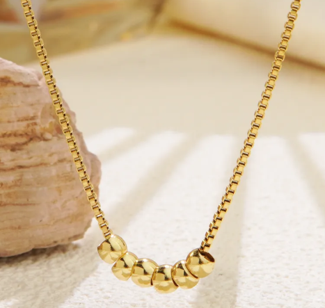 Cadena con dije de 6 bolitas. Color dorado.