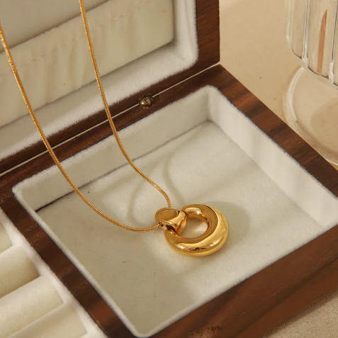 Collar con dije redondo. Color dorado.