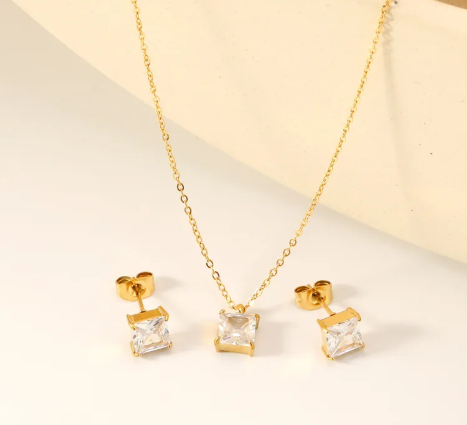 Juego aretes y collar con circonias cuadradas. Color dorado.