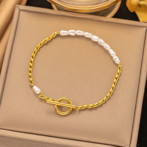 Pulsera delgada de cadena con perla. Color dorado.