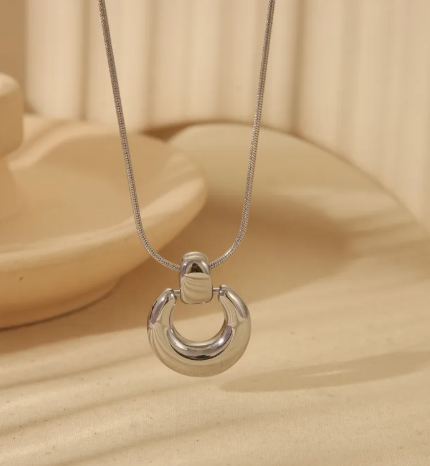 Collar con dije redondo. Color plateado.